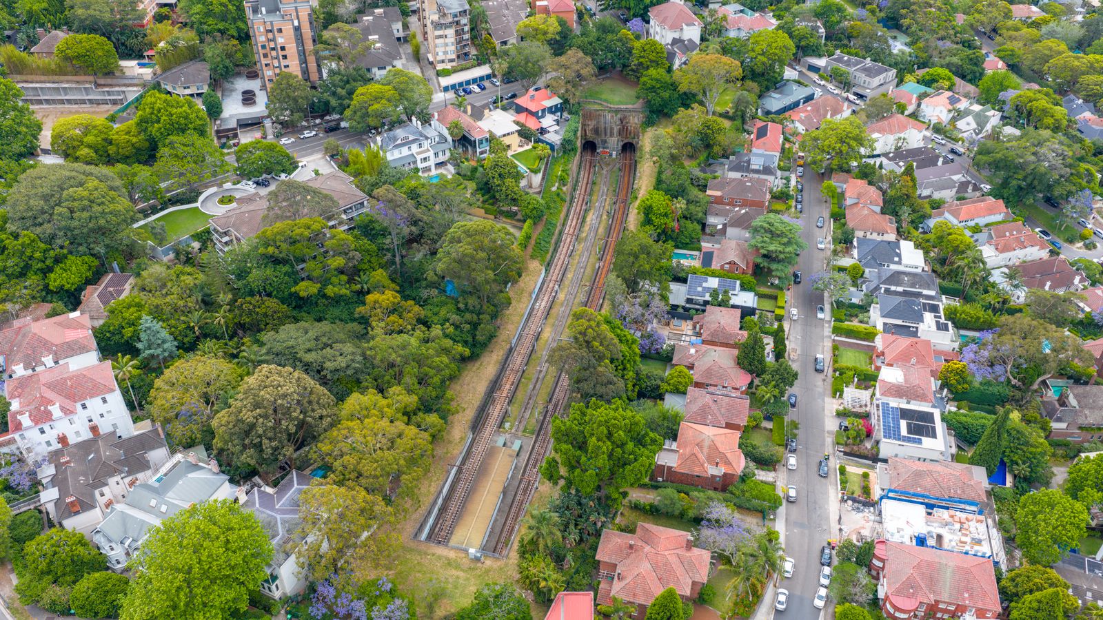 Aerial view of a leafy suburb with houses and a rail line