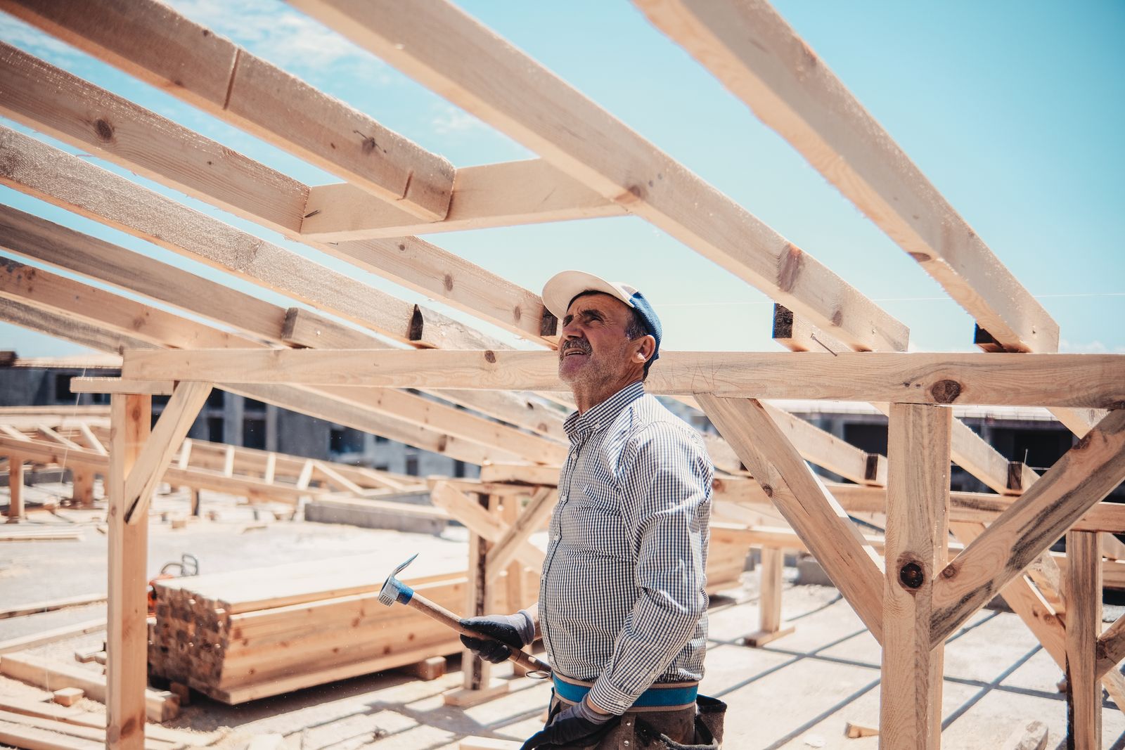 Builder checking a timber roof frame on a sunny day