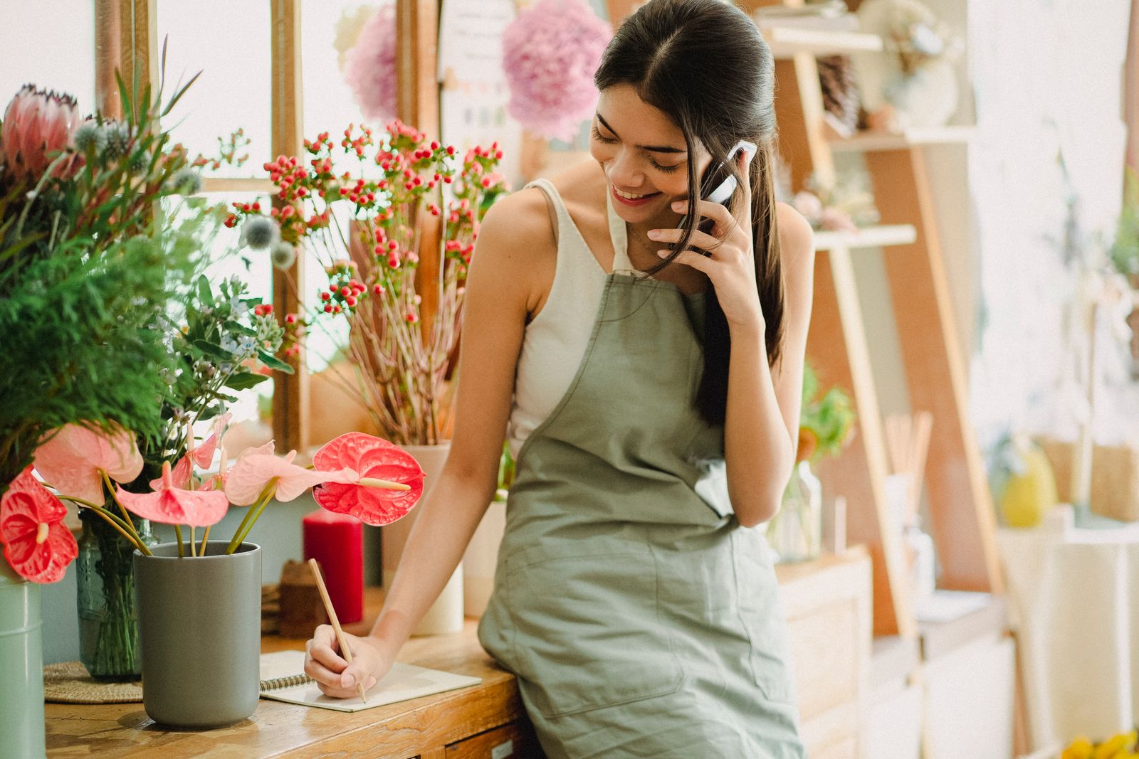 Shop owner in an apron taking a call on a mobile phone