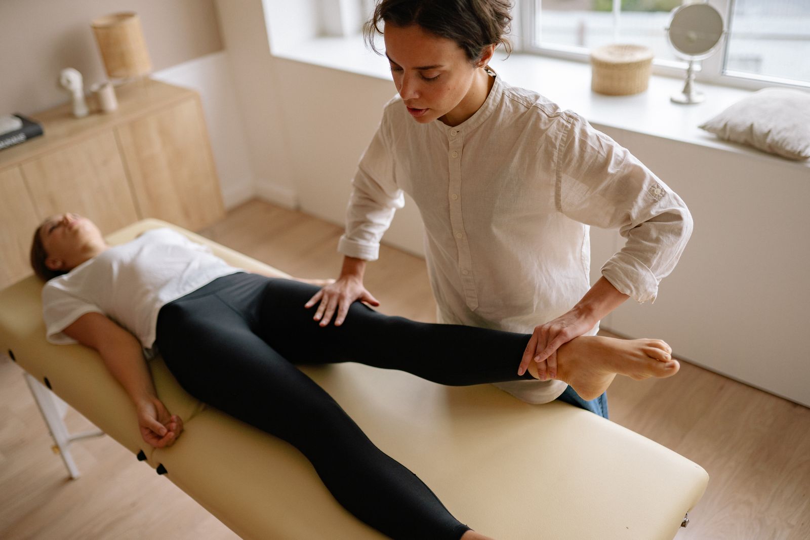 Physiotherapist helping a patient with a leg exercise