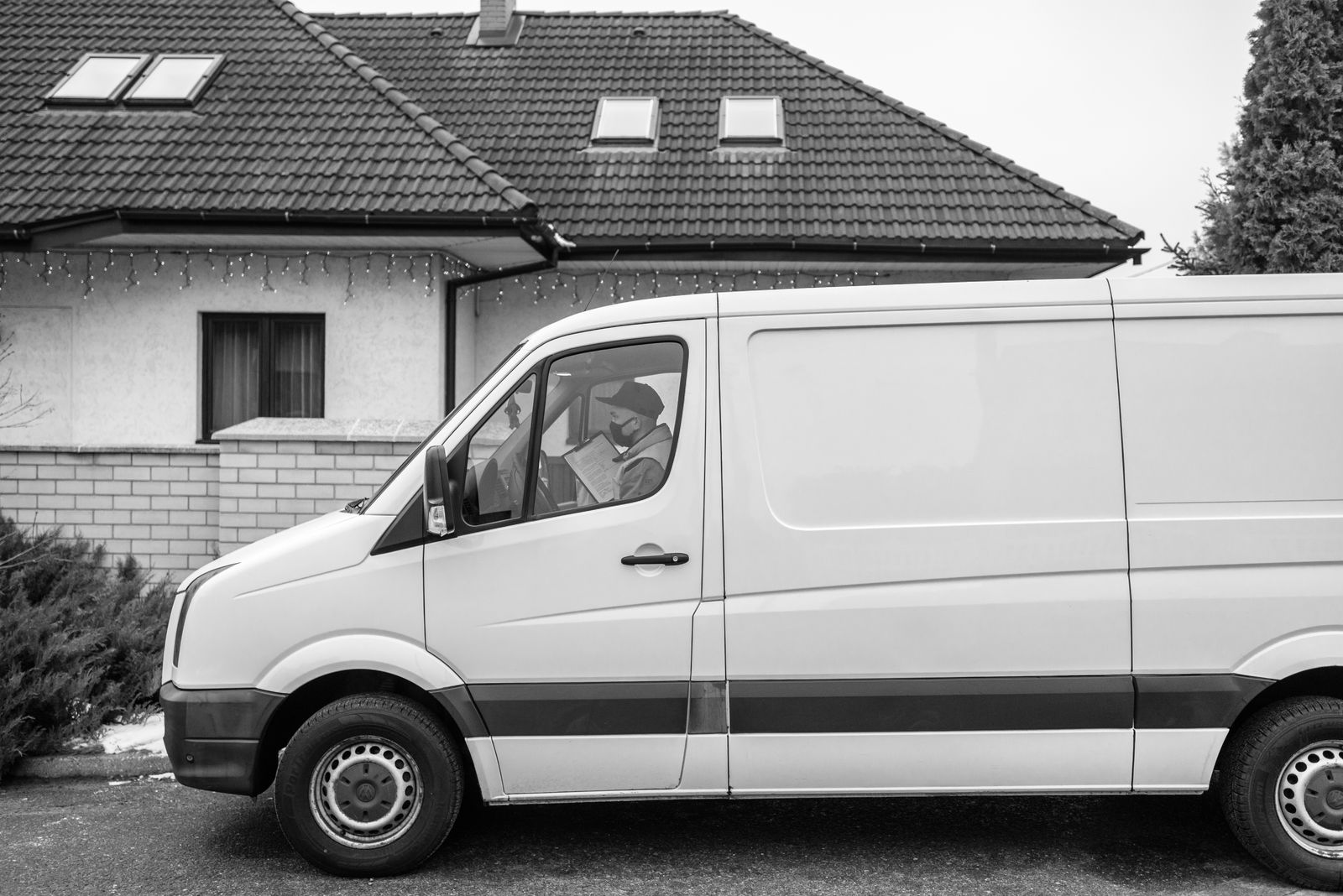 White work van parked outside a house