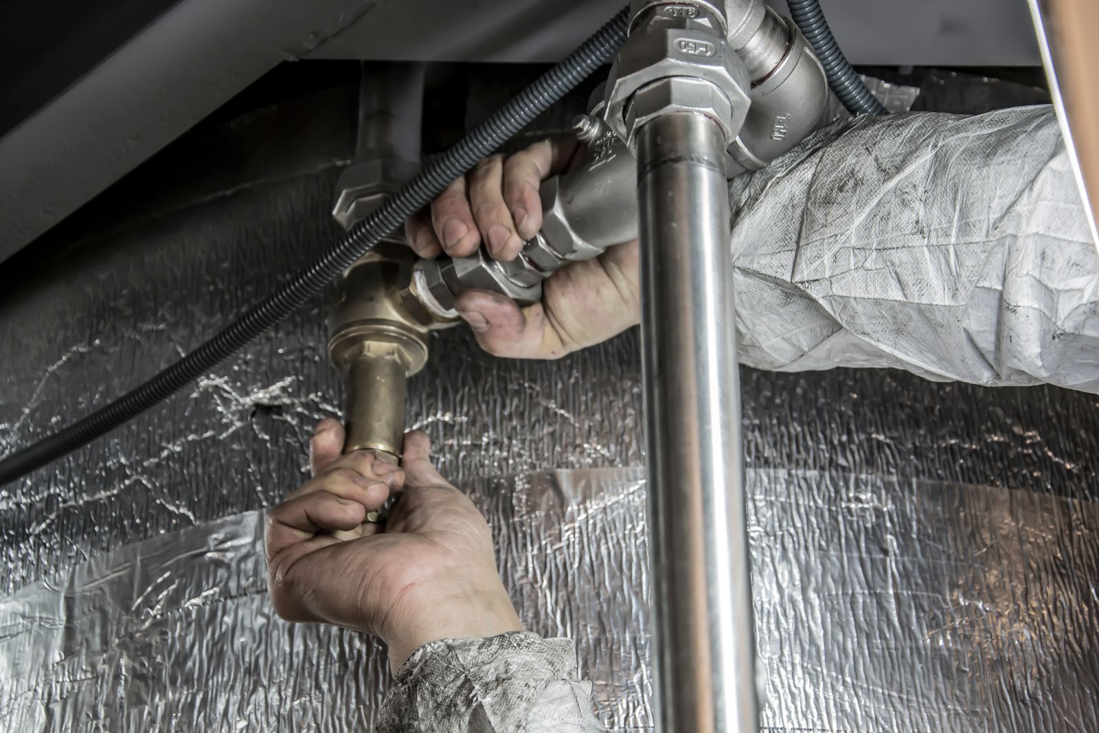 Plumber's hands fitting steel pipework